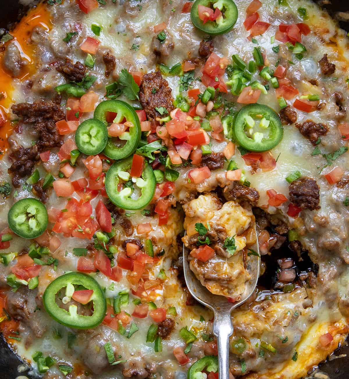 Spoon in a skillet of Queso Fundido.