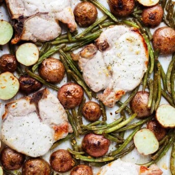 Pork Chops, Green Beans, and Potatoes all baked on one sheet pan.