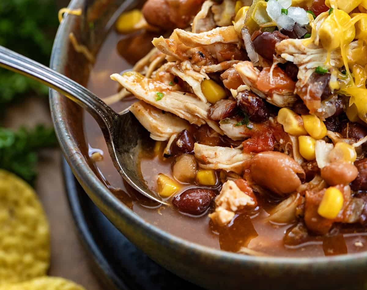 Spoon in a bowl of Slow Cooker Chicken Taco Soup very close up.