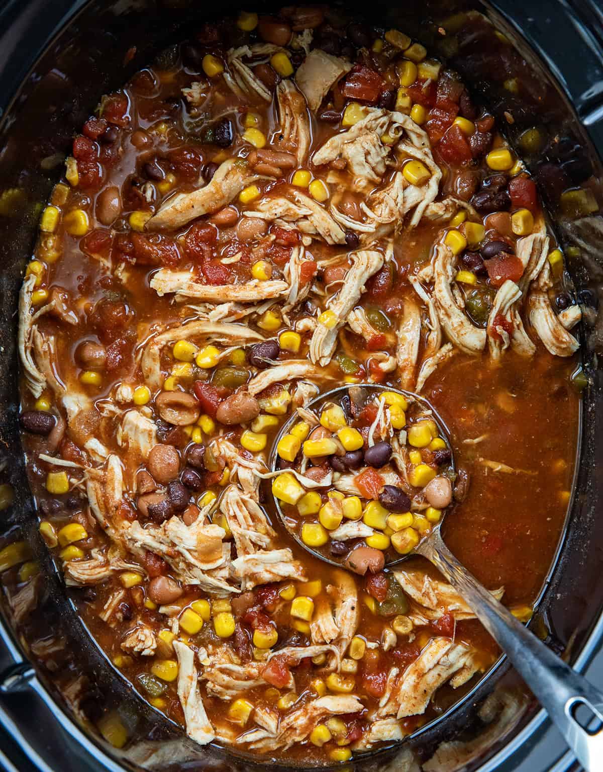 Slow Cooker Chicken Taco Soup in the slow cooker with a ladle. 