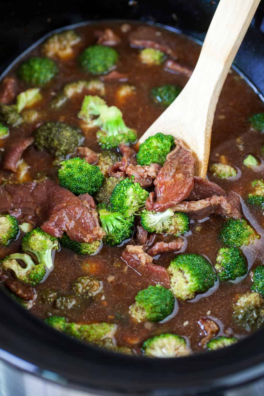 Spoon being dipped into Slow Cooker Beef and Broccoli