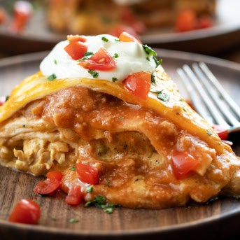 Piece of Chicken Tortilla Casserole on a wooden table close up.