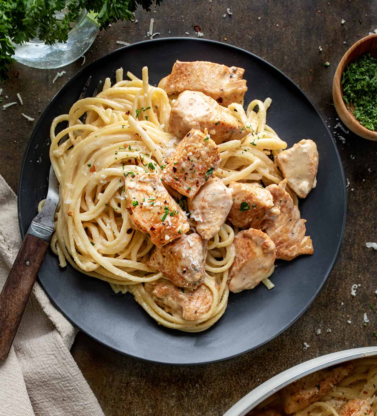 Plate of Creamy Chicken Pasta on a Table with Form and Garnish.