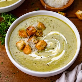 Bowl of Zucchini Soup with homemade croutons, parmesan cheese, and sour cream.