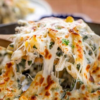 Scooping up Spinach Dip Chicken Pasta from skillet.