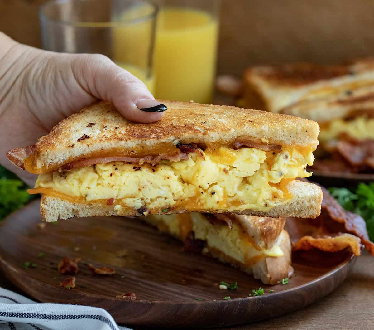 Hand holding half of a Griddle Breakfast Sandwich.