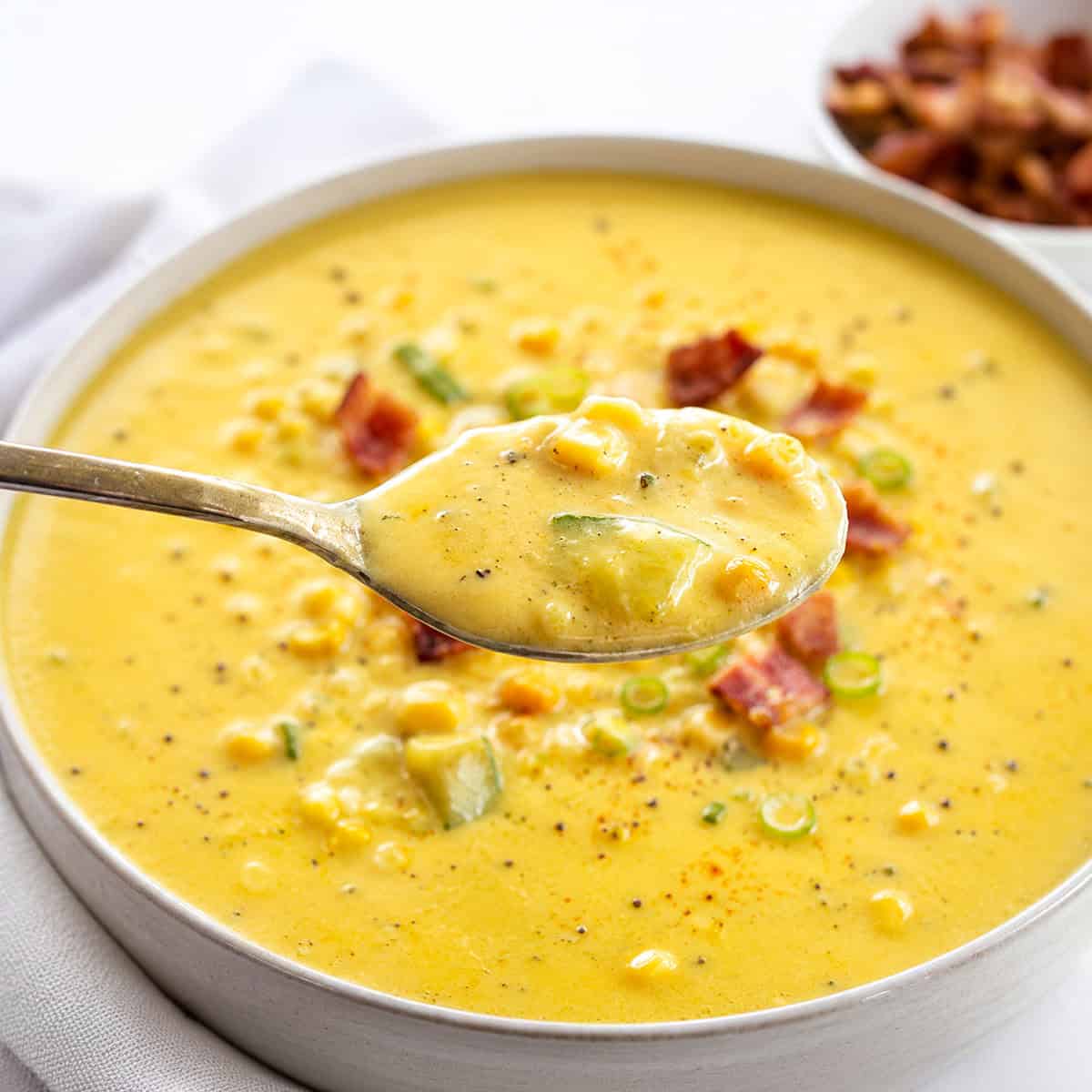 Spoonful of Zucchini Chowder held above the bowl.