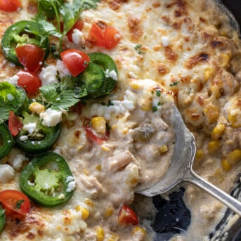 Skillet with Spoon in it with White Bean Chili Cheese Dip.