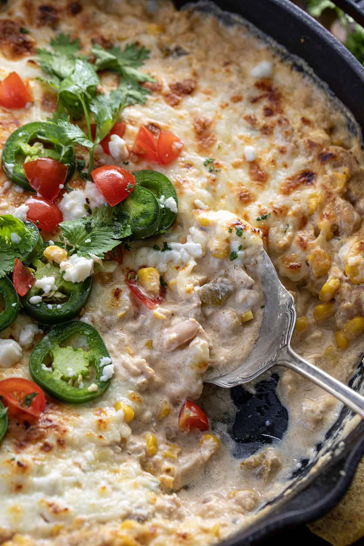 Skillet with Spoon in it with White Bean Chili Cheese Dip.