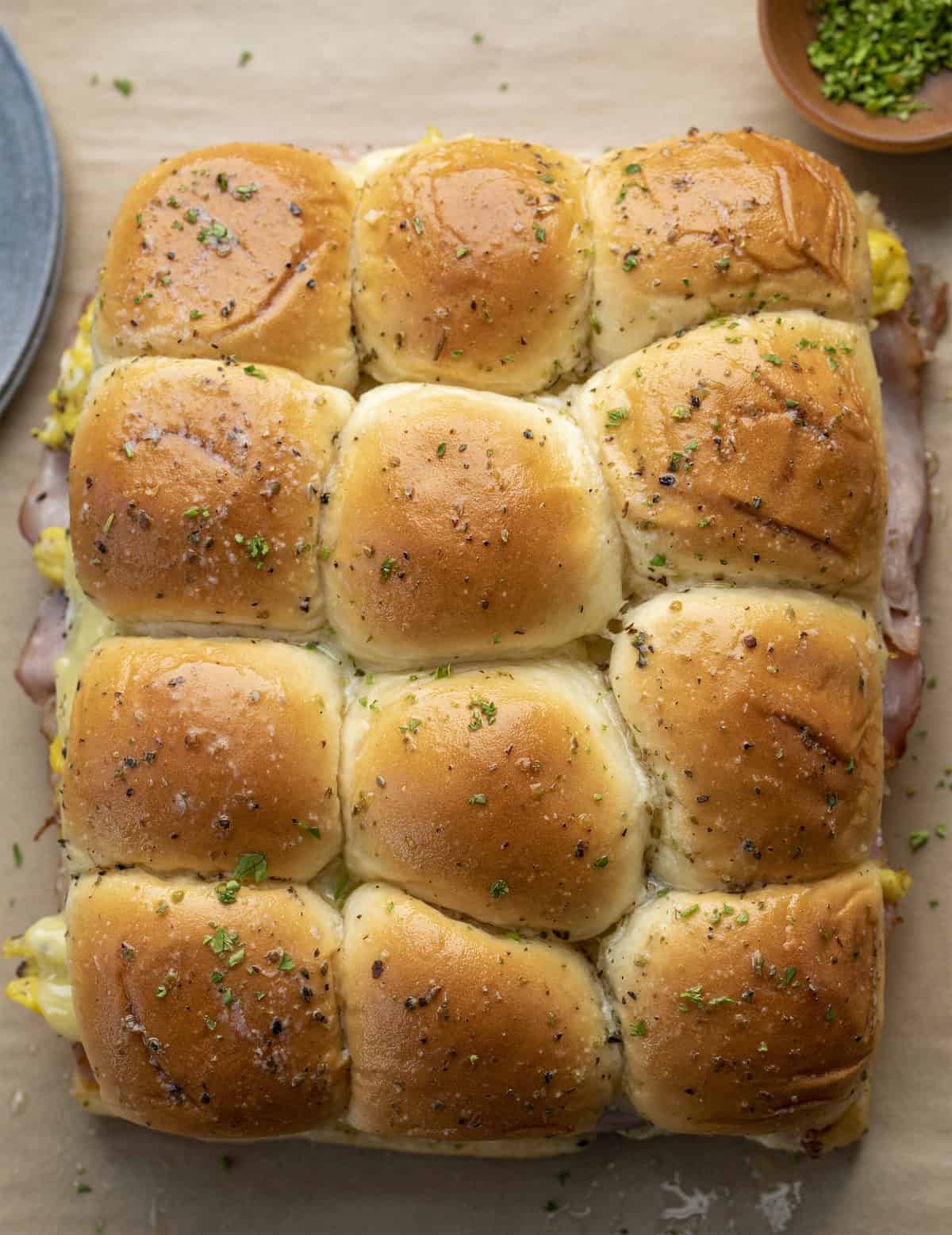 Overhead of Breakfast Sliders with Ham, Cheese, and Scrambled Egg Showing Seasoned Butter