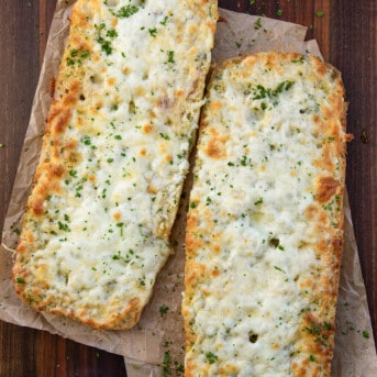 Loaves of Garlic Cheese Bread on parchment paper from overhead.
