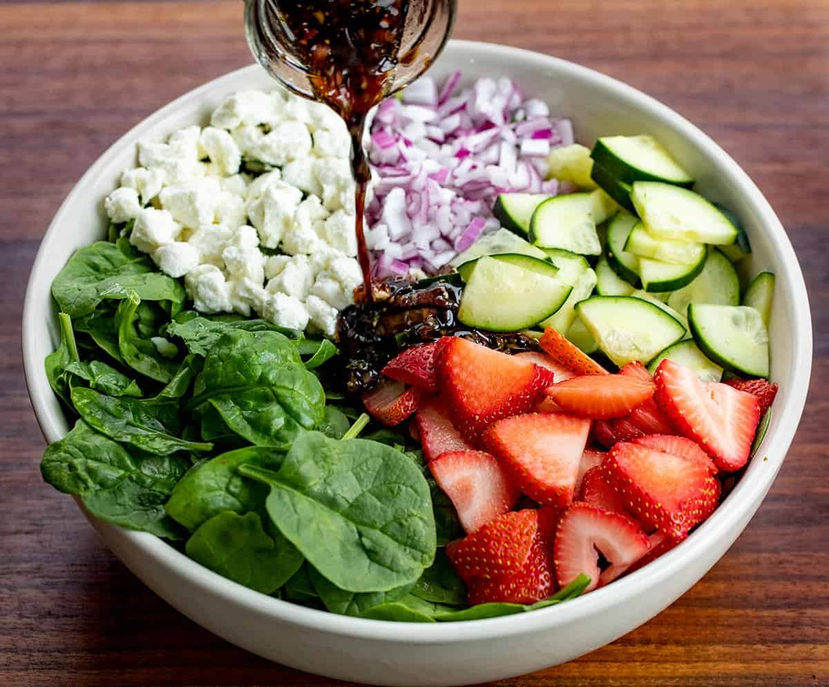 Pouring Balsamic Dressing OVer Strawberry Chicken Salad.