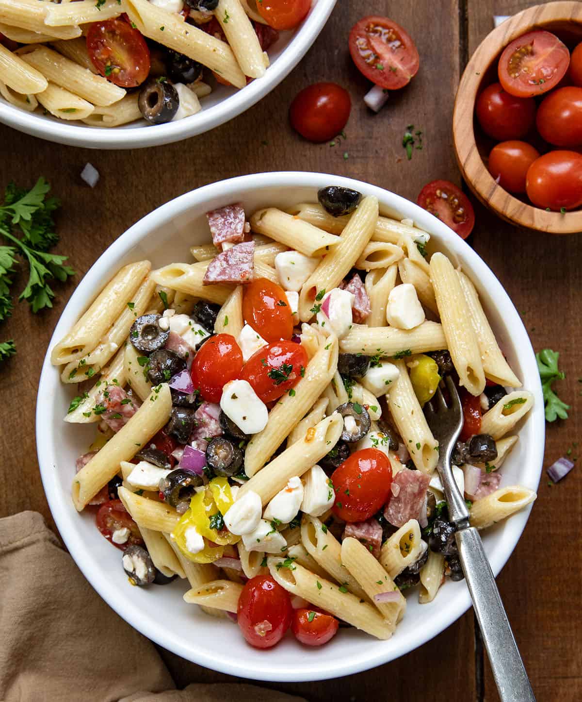 Bowls of Italian Pasta Salad on a wooden table from overhead.