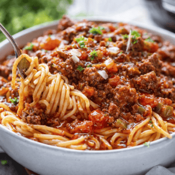Fork twirling spaghetti from a bowl of Homemade Spaghetti with Meat Sauce.
