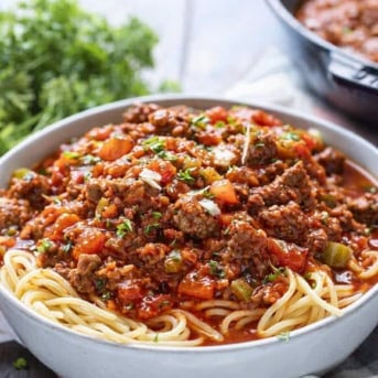 Bowl of Homemade Spaghetti with Meat Sauce on a wooden table.