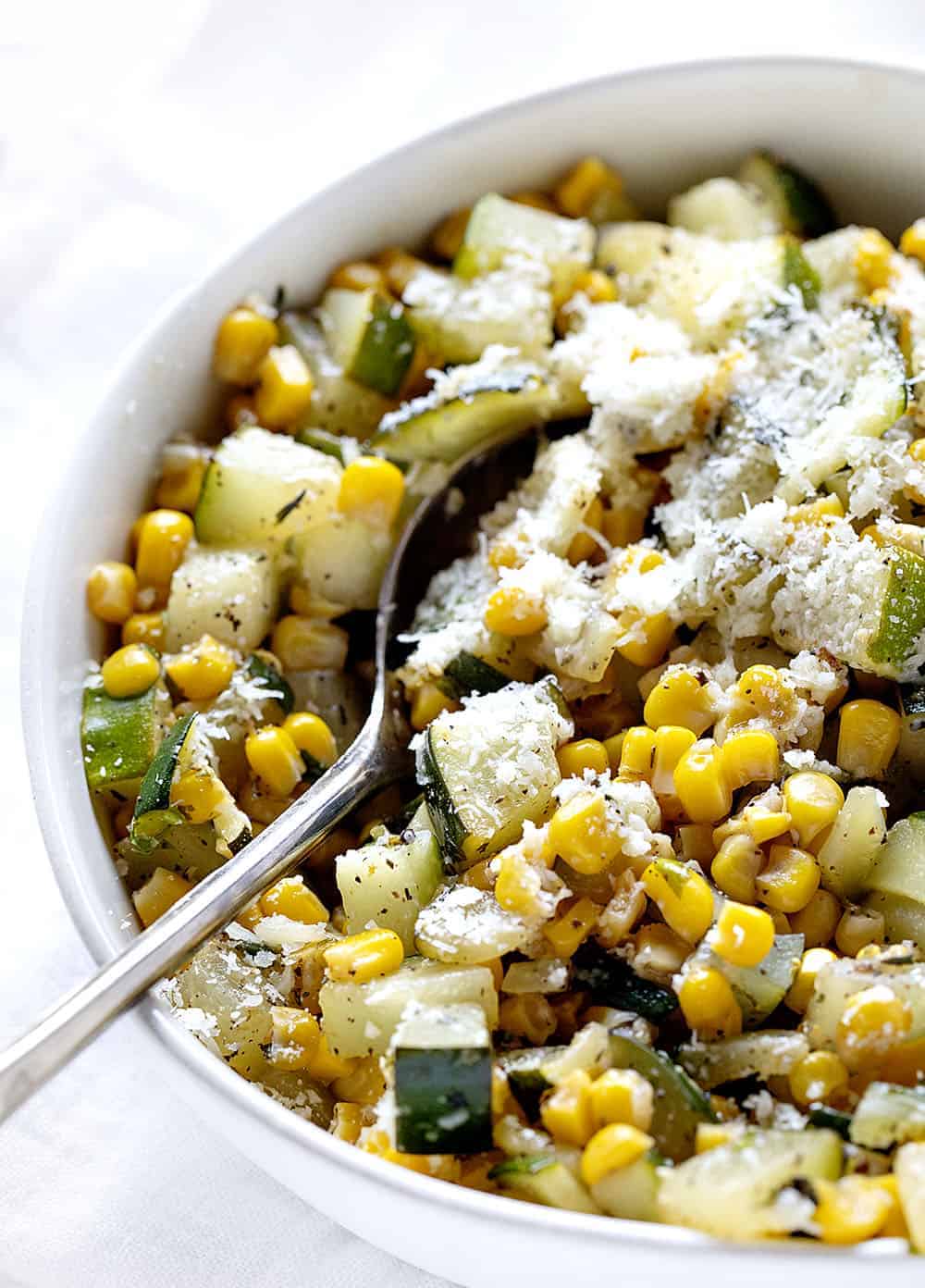 Bowl with Parmesan Zucchini Corn and a Spoon in it