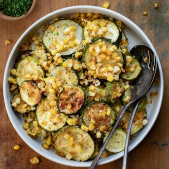 Bowl of Roasted Zucchini and Corn with spoons from overhead.