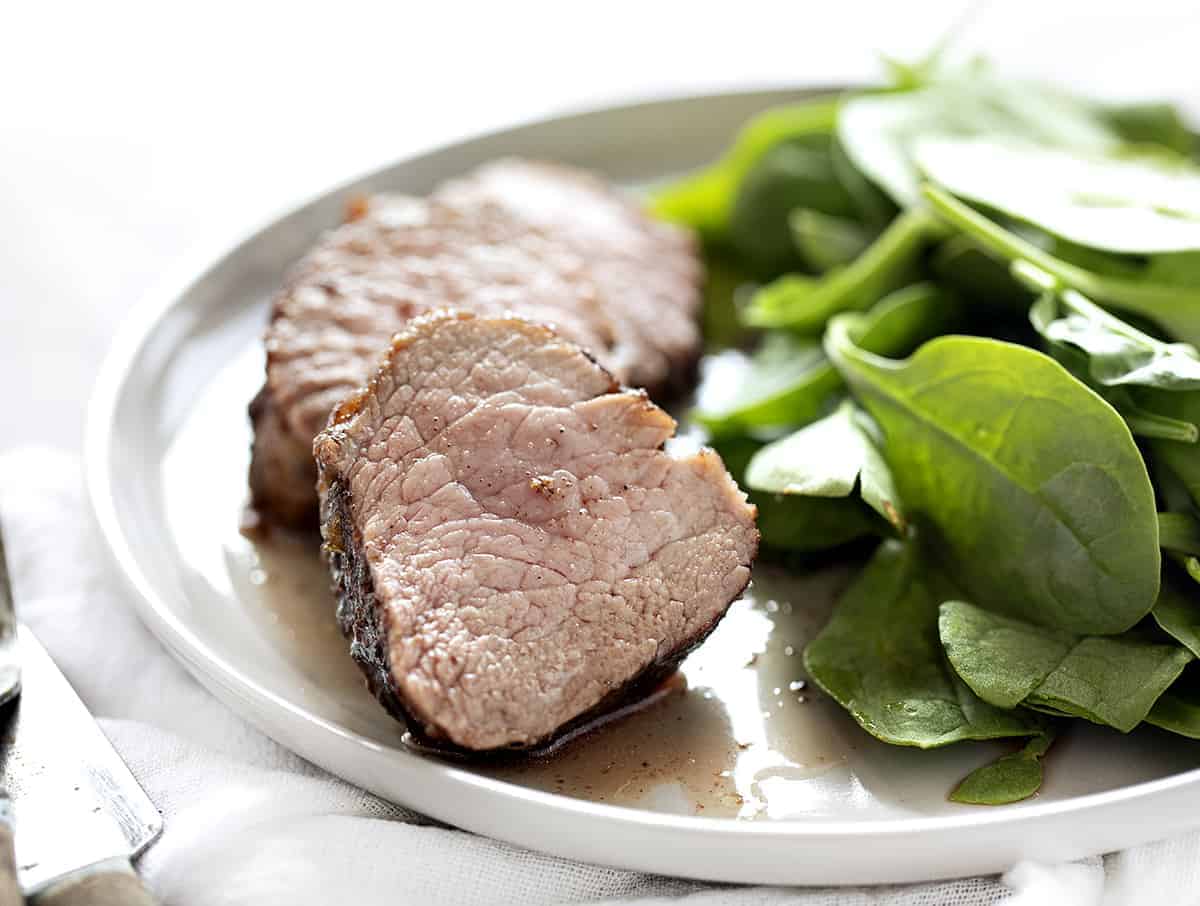 Two slices of Pumpkin Spice Pork Tenderloin with spinach