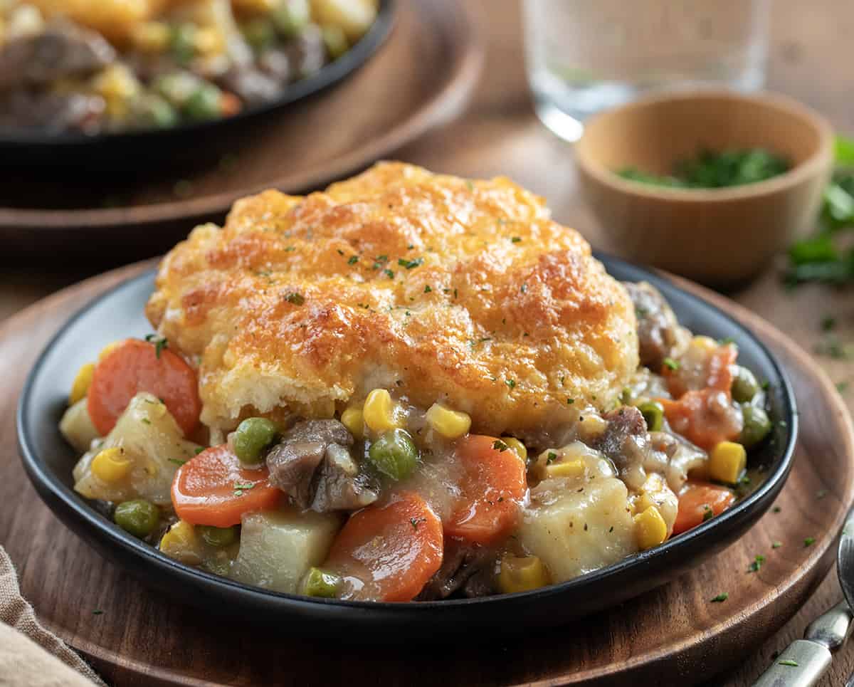 Plate of Beef Pot Pie Casserole showing tender vegetables and cheesy biscuit.
