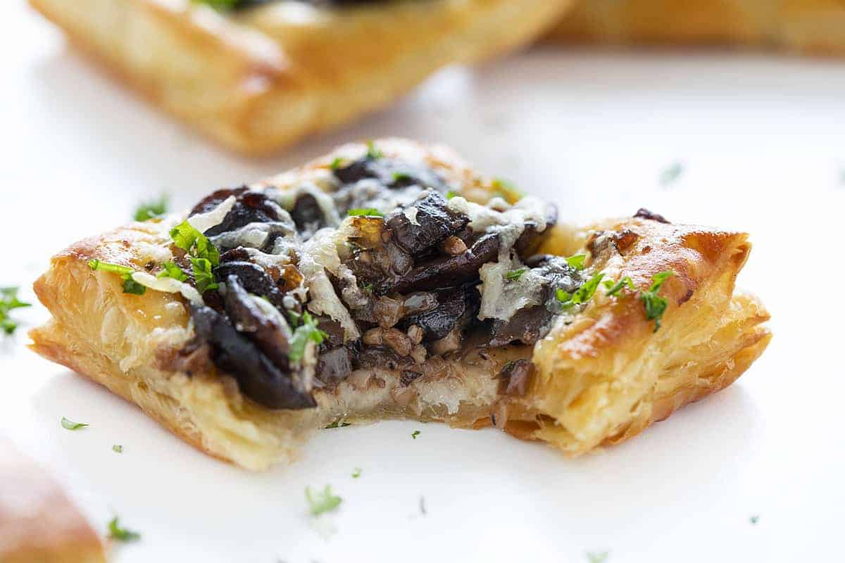 Cheesy Mushroom Pastries with Bite Taken out of It