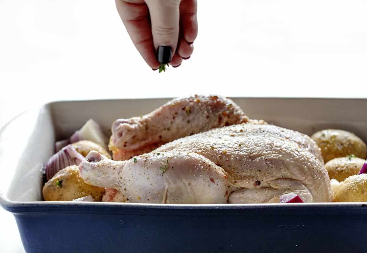 Seasoning raw chicken in a pan