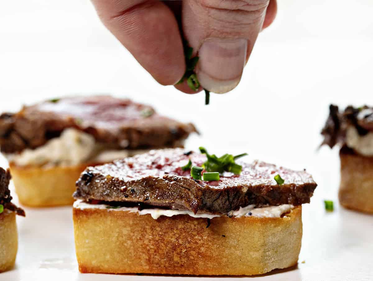 Sprinkling Chives on a Beef Tenderloin Baguette Appetizer