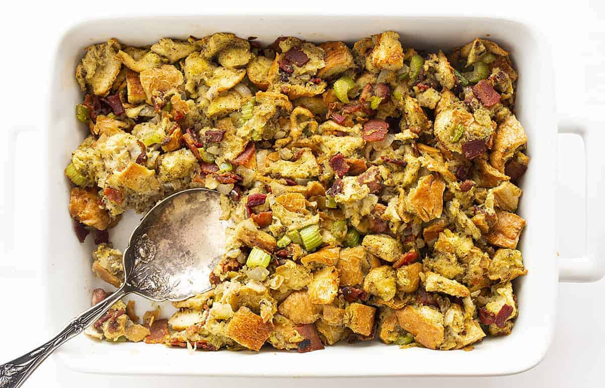 Overhead of bacon stuffing in baking dish with spoon