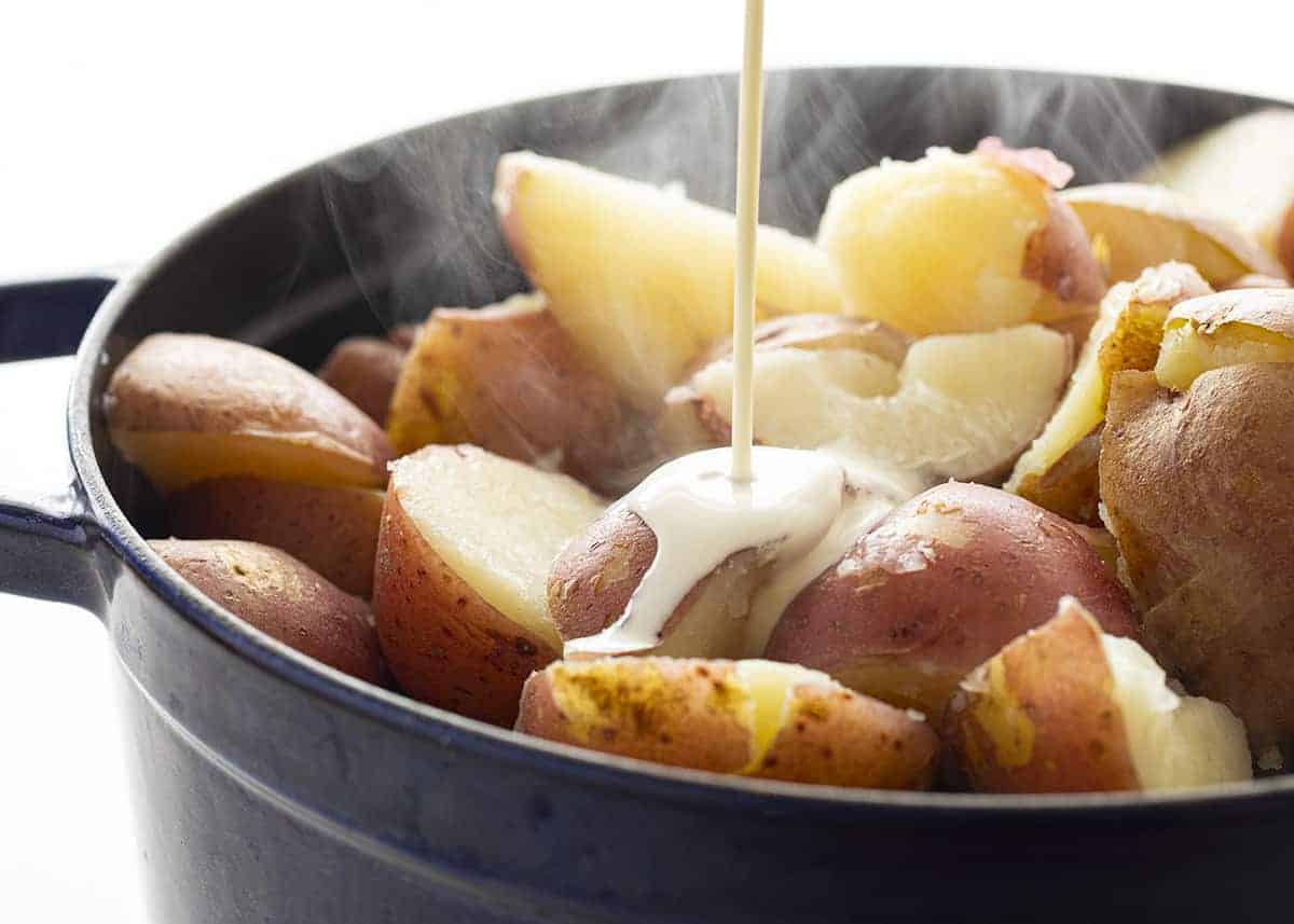 Pouring Cream into Pot with Boiled Mashed Potatoes