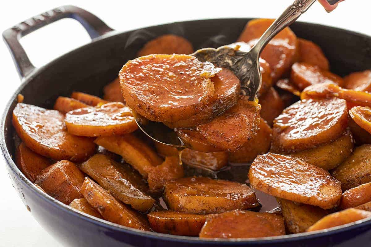 Spoonful of Steaming Hot Candied Yams in a Blue Skillet.  