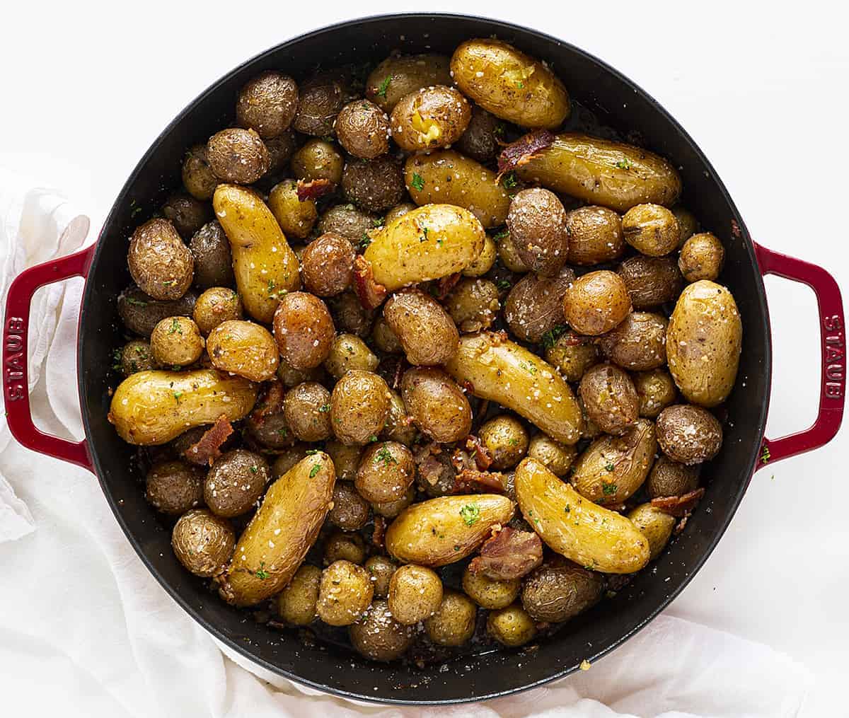 Roasted Potatoes with Bacon OVerhead View in Red Skillet on White Napkin