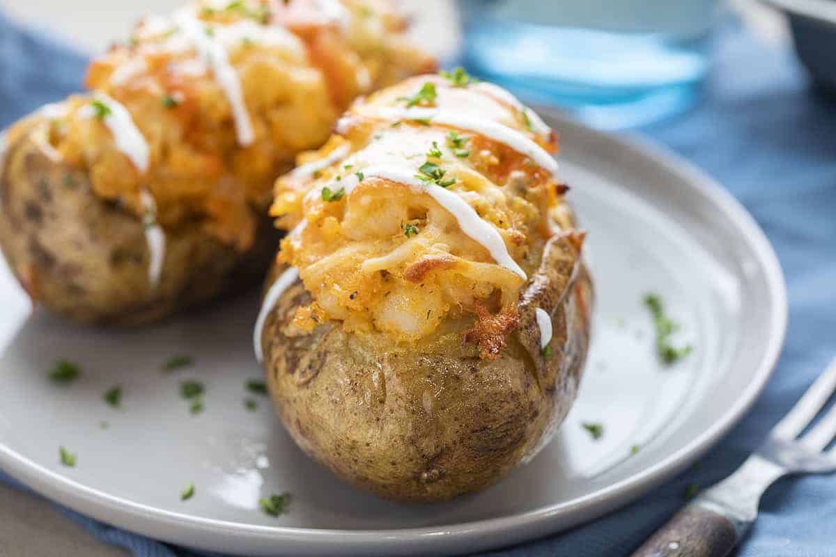 Two Buffalo Chicken Twice Baked Potatoes on Grey Plate with Fork and Water