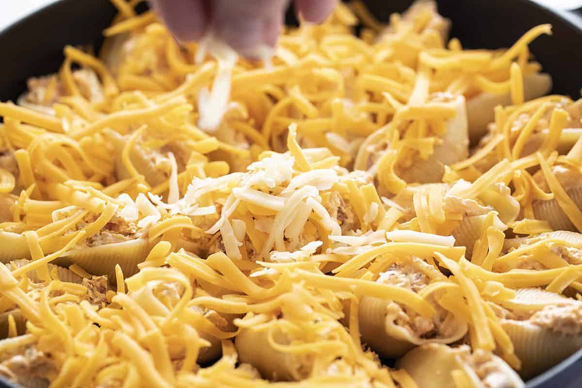 Sprinkling Cheese over Chicken Ranch Stuffed Shells
