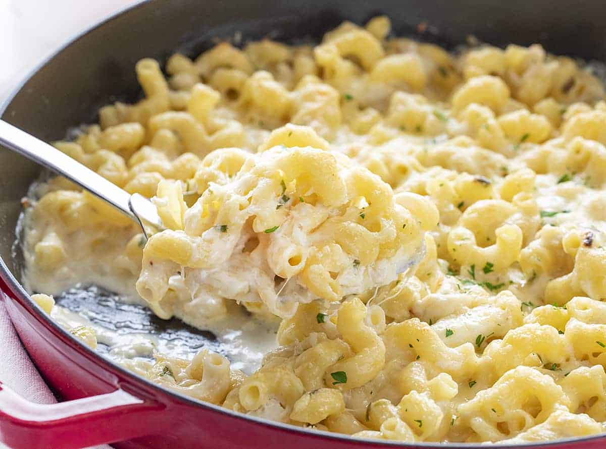 Crab and Macaroni and Cheese Being Scooped Out of a Pan
