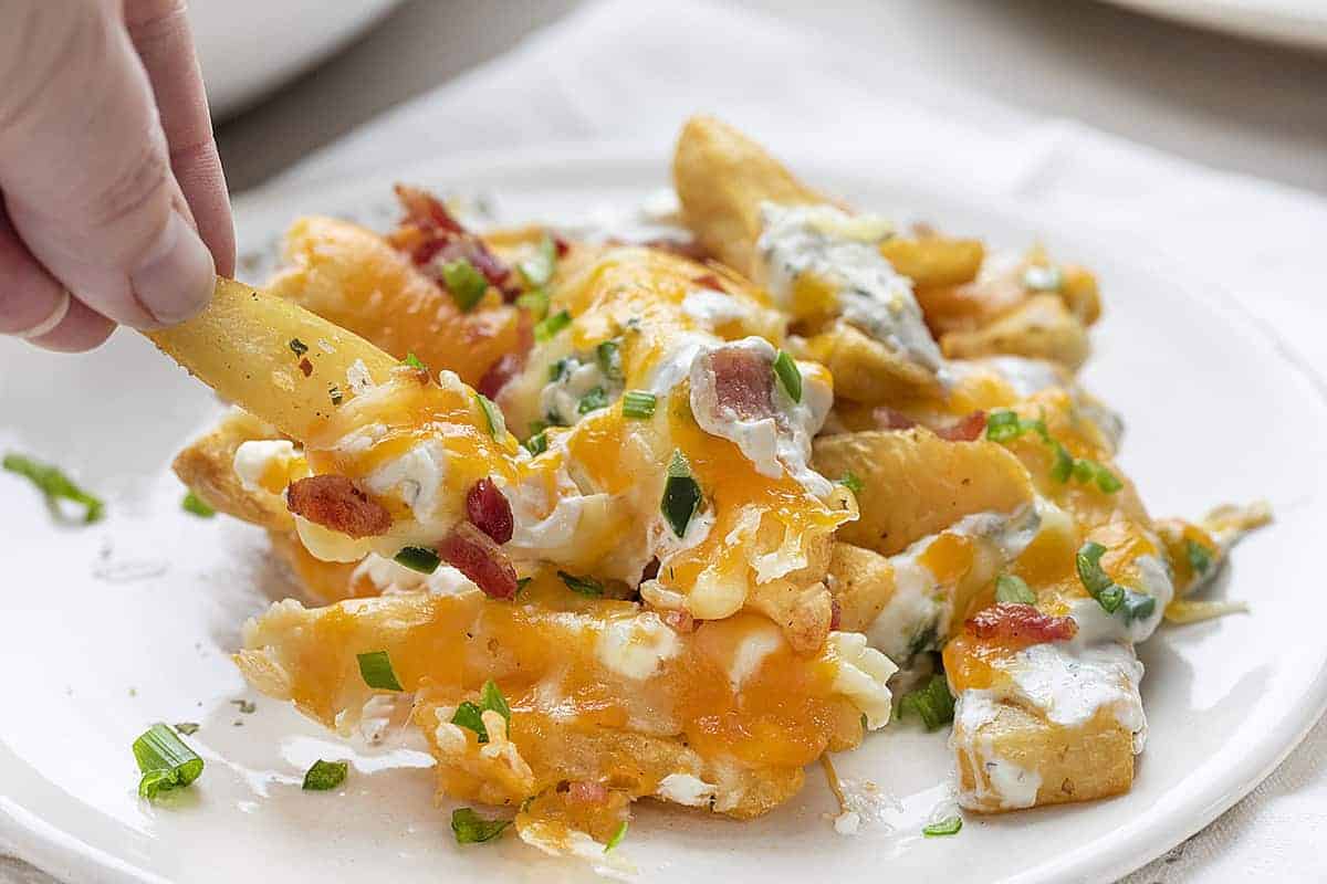Hand Picking Up Jalapeno Popper Cheese Fries Recipe