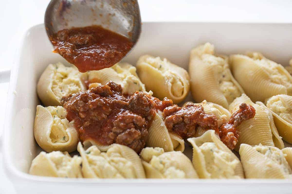 Pouring Sauce over Stuffed Shells
