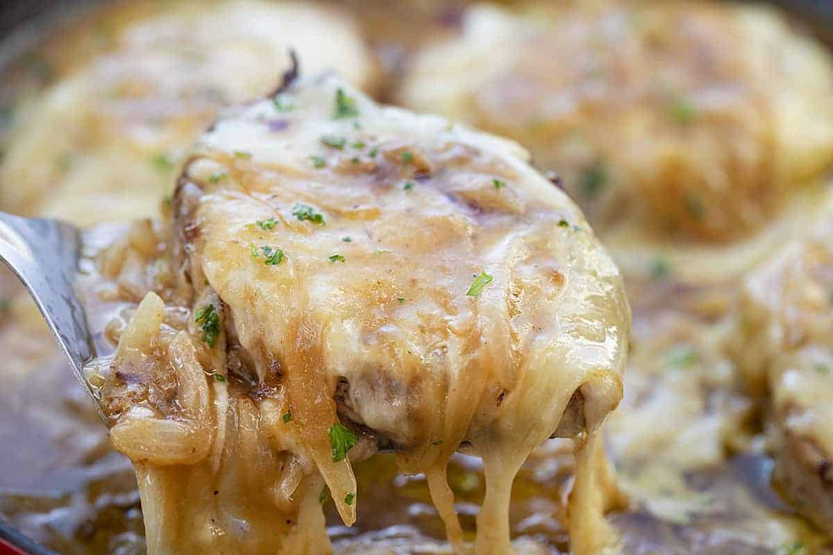 French Onion Pork Chop Being Lifted Out of Pan