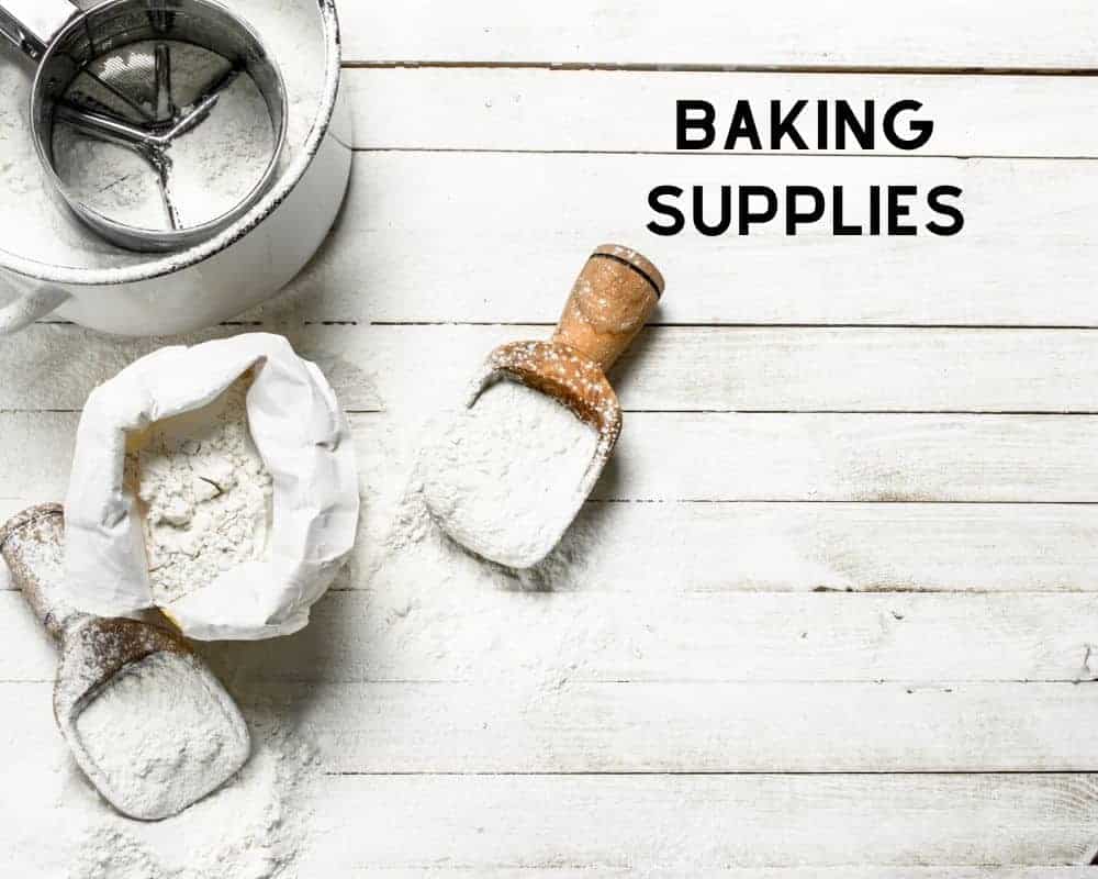 Essential Baking Supplies like flour and sugar on wooden surface