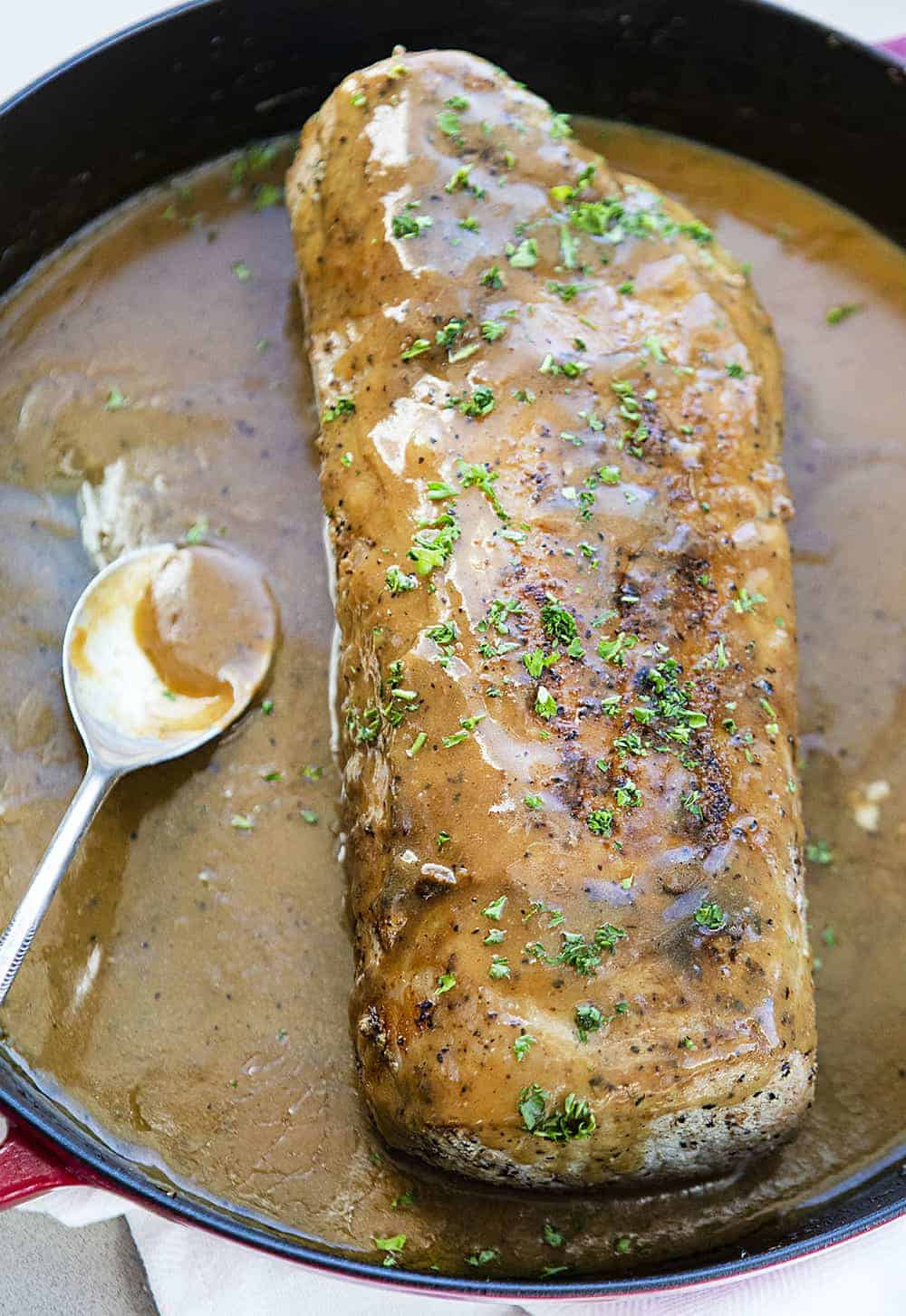 Roasted Pork Loin with Gravy in a Skillet with Spoon