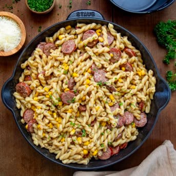Skillet of Smoked Sausage Pasta on a wooden table from overhead.