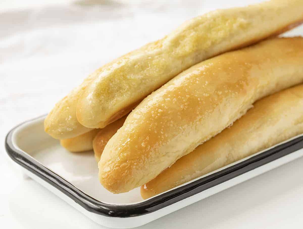 Copycat Olive Garden Breadsticks Stacked on a Platter - Garlic Breadsticks