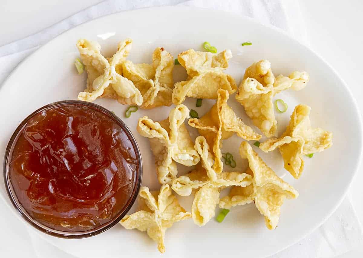 Overhead Image of Homemade Cream Cheese Wontons with Homemade Sweet and Sour Sauce Next to It