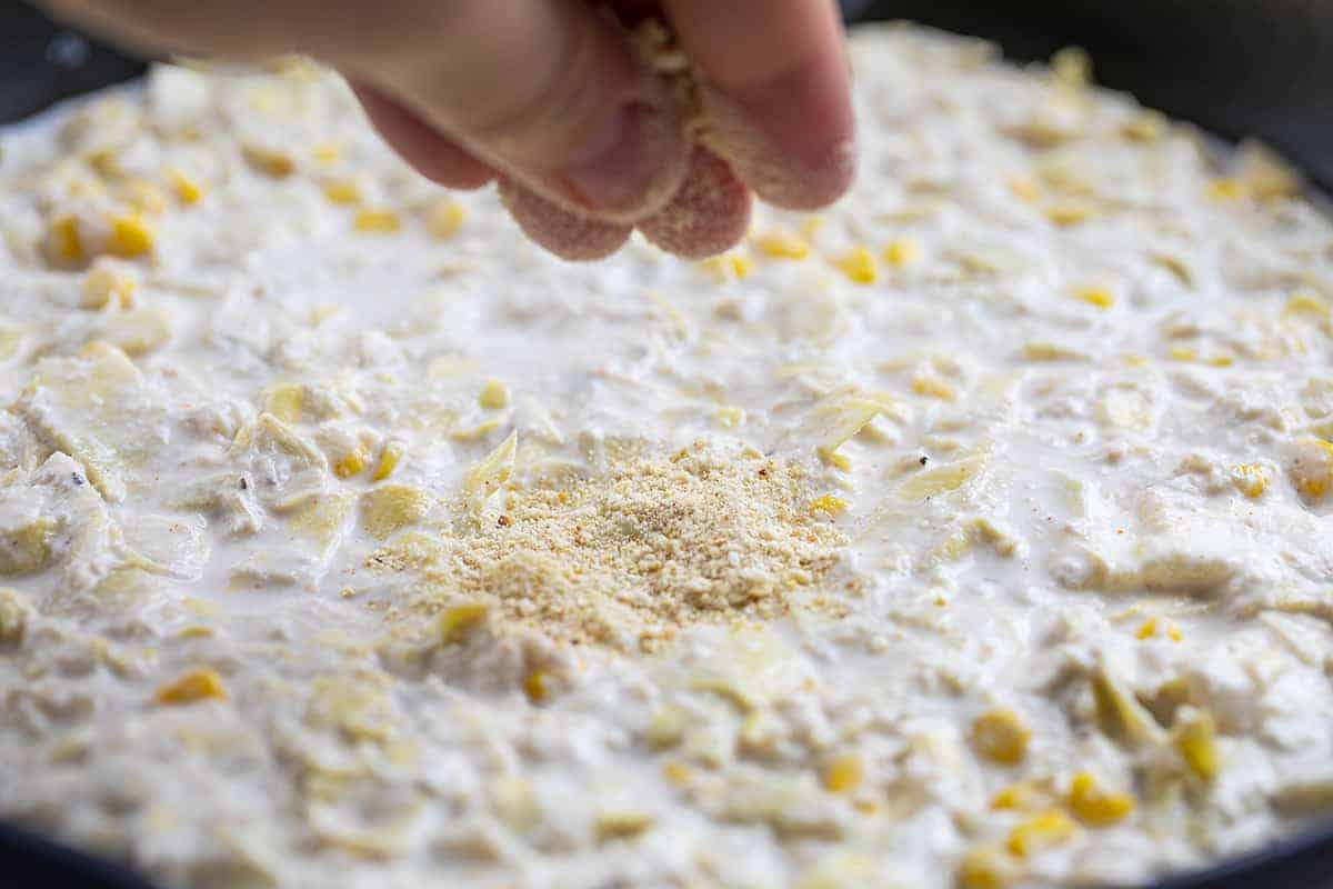 Sprinkling Breadcrumbs on Copycat Cheesecake Factory Warm Crab and Artichoke Dip