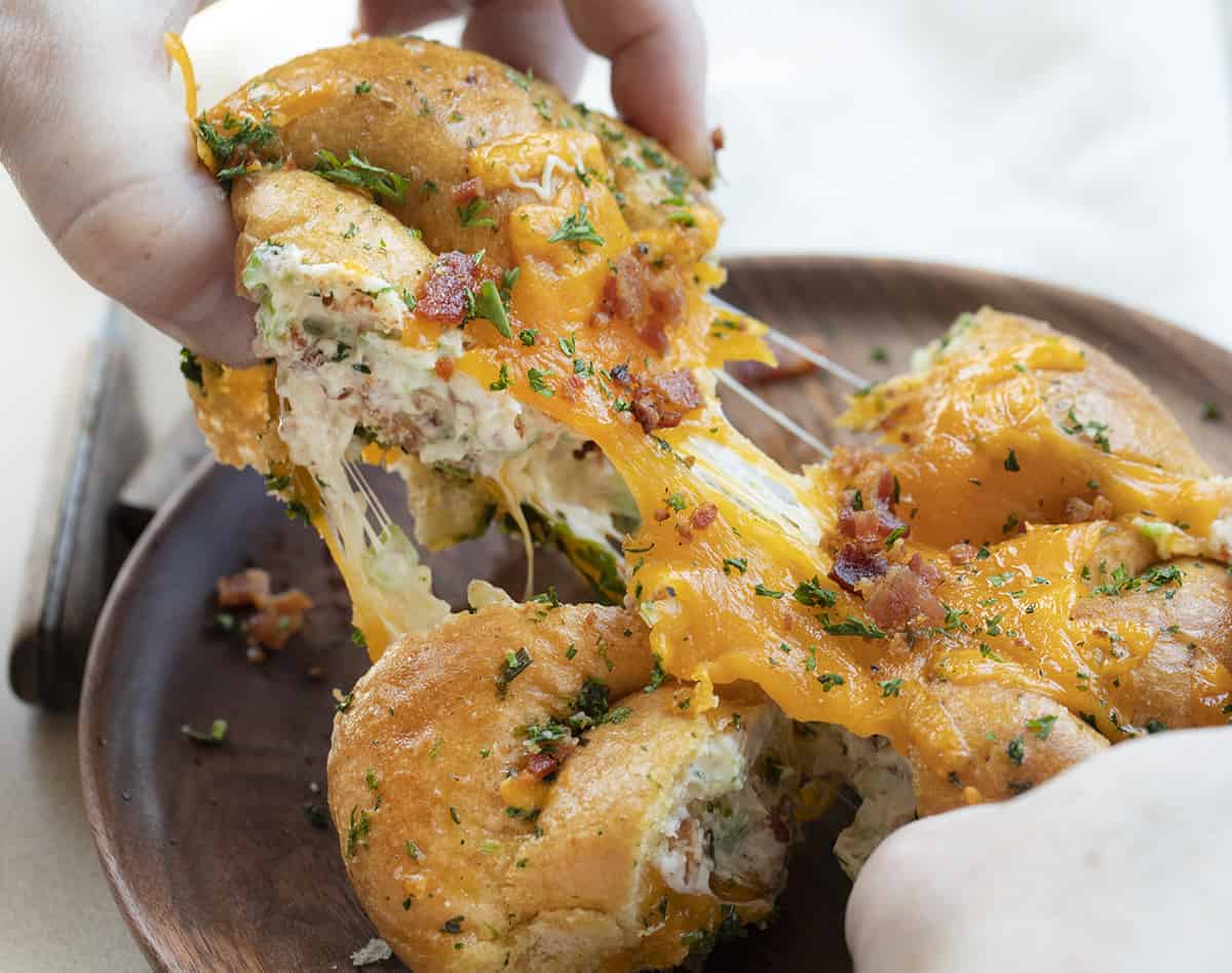 Hands holding Jalapeno Popper Cheesy Pull Apart Bread and Pulling it Apart