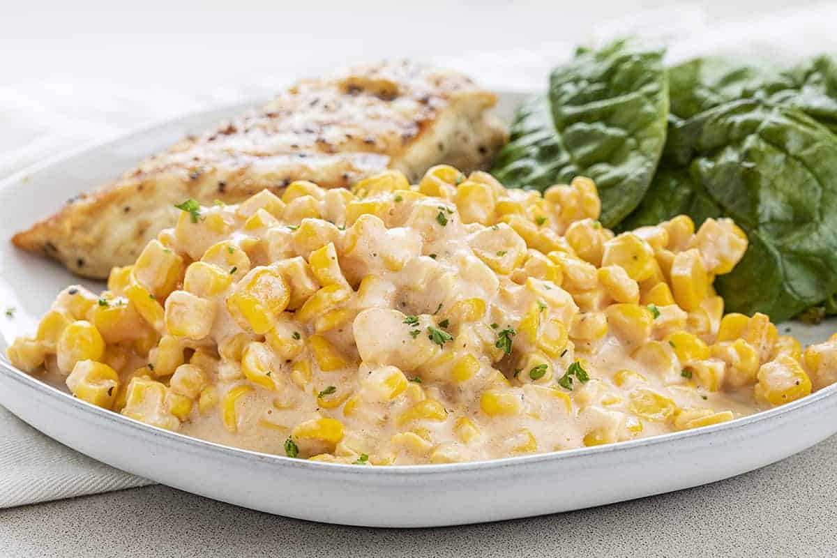Plate with Crockpot Cheesy Corn on it and Chicken