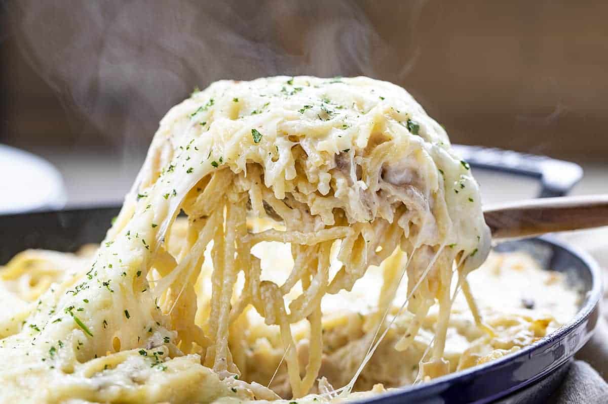 Scooping up a Portion of Chicken Tetrazzini from Skillet 