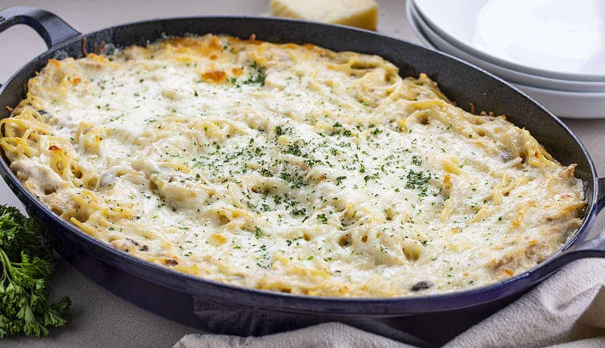 Chicken Tetrazzini in a Blue Skillet with Bowls Behind