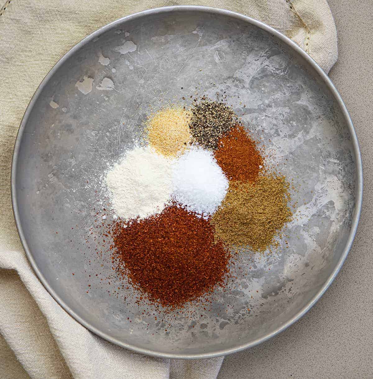 Overhead Image of Raw Spices Before Being Mixed for Homemade Chili Powder on Metal Plate with Cream Towel