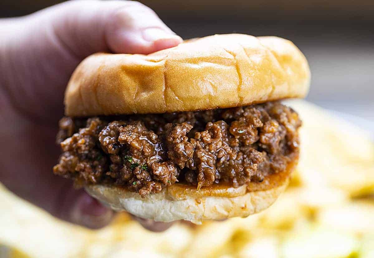 Hand Holding Sloppy Joe on a Bun