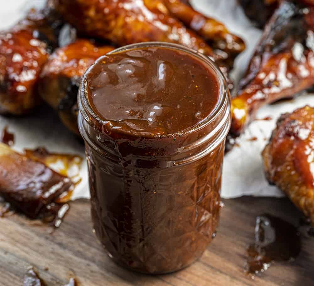Jar of Homemade BBQ Sauce Surrounded By Chicken