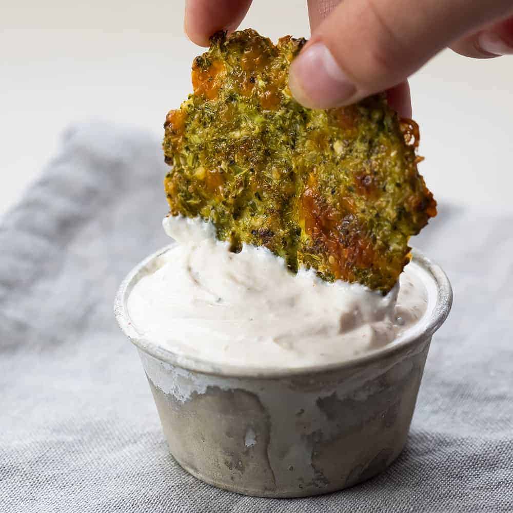 Hand Dipping Baked Broccoli Bite into Homemade Sauce